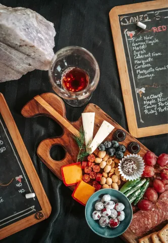 top view of charcuterie board on table with wine and menus